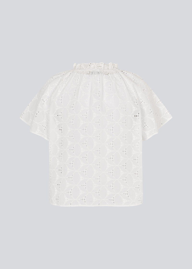 Top with short sleeves in broderie anglaise. NanetteMD SS top has a loose fit and an opening in front with a button closure.