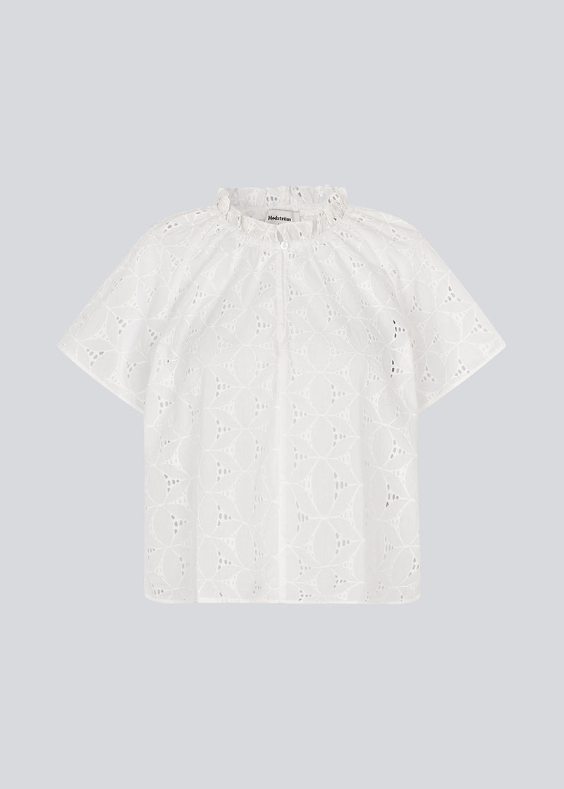 Top with short sleeves in broderie anglaise. NanetteMD SS top has a loose fit and an opening in front with a button closure.