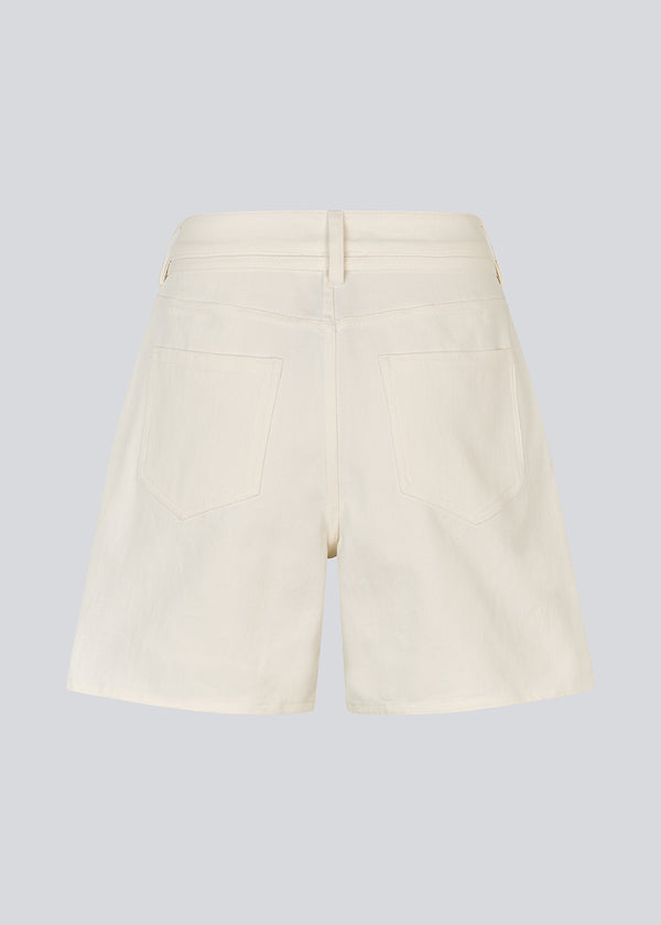 White denim shorts with wide legs in cotton denim. Naomamd solid shorts have a high waist, front and back pockets, and a tie band at the waist.