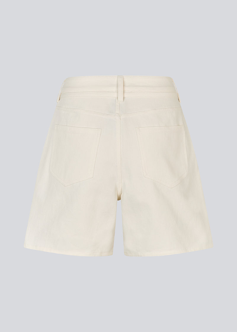 White denim shorts with wide legs in cotton denim. Naomamd solid shorts have a high waist, front and back pockets, and a tie band at the waist.