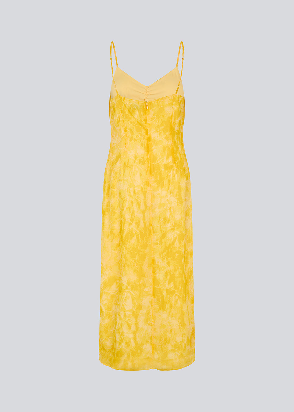 Maxi dress in yellow with thin straps and an elastic gathering at the chest. Napthalimd print strap dress has a slit in the front and an invisible zipper at the back.