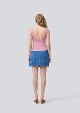 Sleeveless pink top in a shimmery knit. NavalMD top has a round neckline and a deep back.