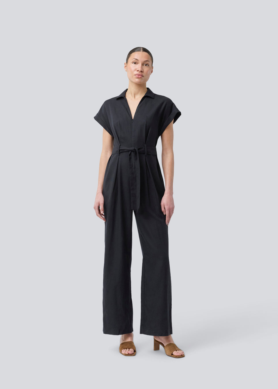Black jumpsuit with wide legs and a tieband at the waist. NedraMD jumpsuit has a collar, v-neck, and a zipper at front.