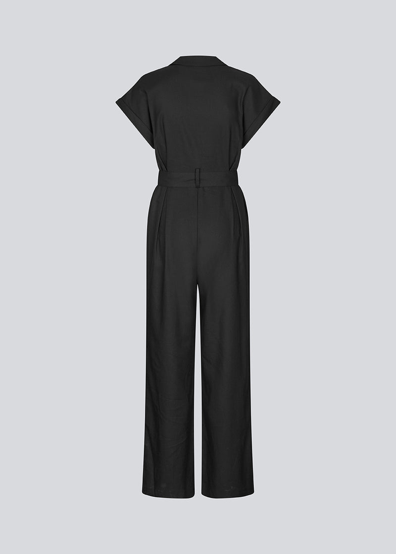 Black jumpsuit with wide legs and a tieband at the waist. NedraMD jumpsuit has a collar, v-neck, and a zipper at front.