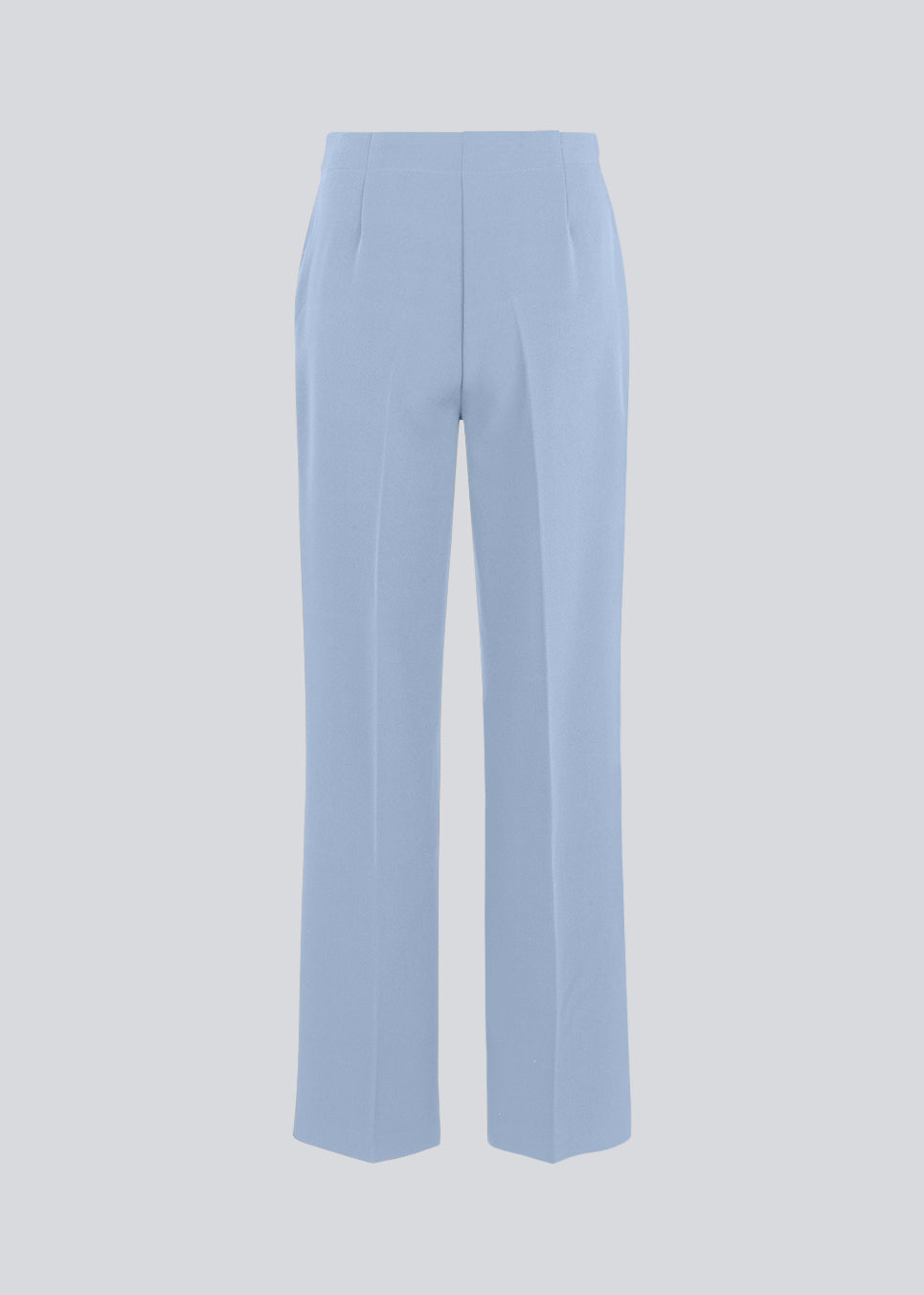 Classic pants in light blue with pressfolds and straight legs. Nelli pants are closed by an hidden zipper at the side with an elastic waistband for a more comfortable fit. The model is 175 cm and wears a size S/36
