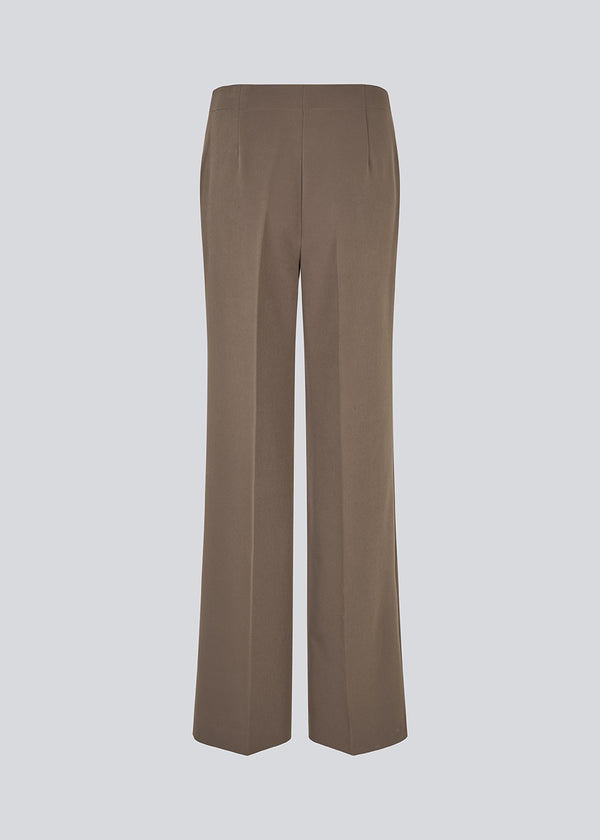 Classic pants with pressfolds and straight legs. Nelli pants are closes by an hidden zipper at the side with an elastic waistband for a more comfortable fit.&nbsp;