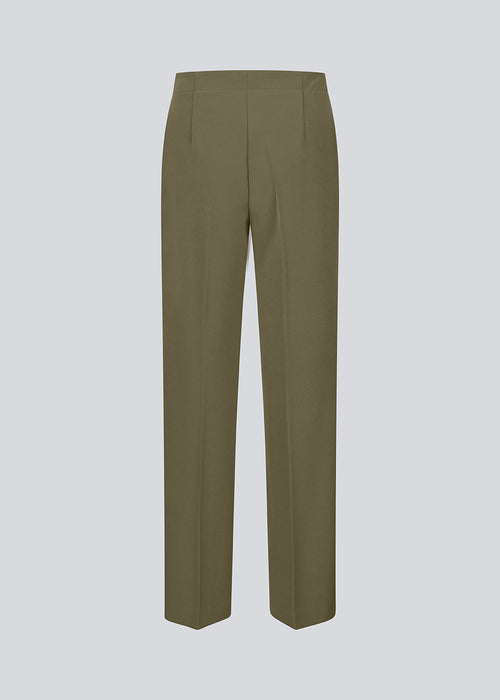 Classic dark green pants with pressfolds and straight legs. Nelli pants are closes by an hidden zipper at the side with an elastic waistband for a more comfortable fit.