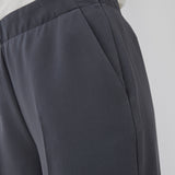 Classic pants in grey with pressfolds and straight legs. Nelli pants are closed by a hidden zipper at the side with an elastic waistband for a more comfortable fit. The model is 173 cm and wears a size S/36