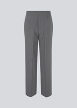 Classic pants in grey with pressfolds and straight legs. Nelli pants are closed by a hidden zipper at the side with an elastic waistband for a more comfortable fit. The model is 173 cm and wears a size S/36