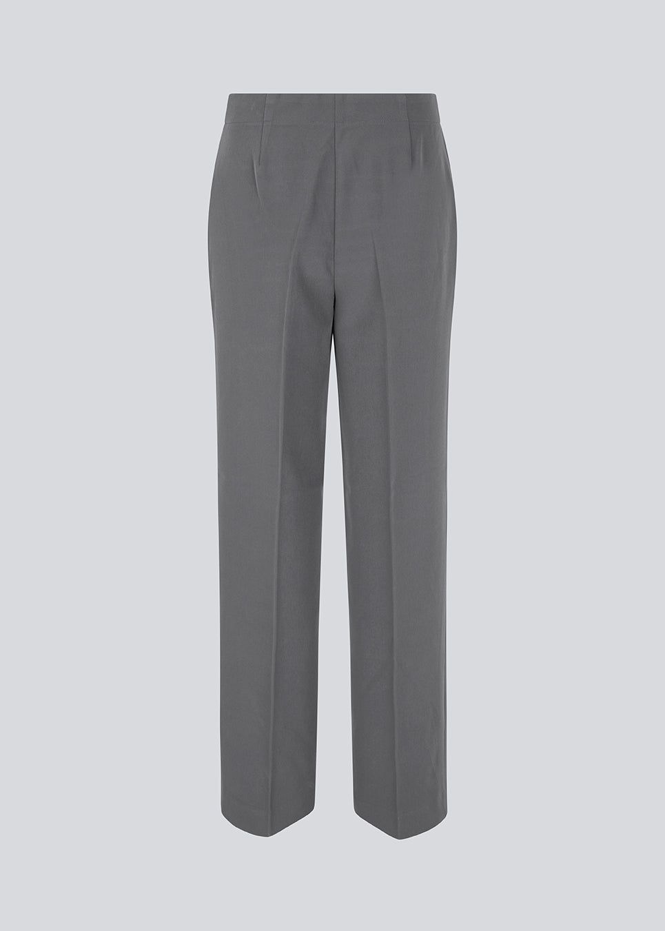 Classic pants in grey with pressfolds and straight legs. Nelli pants are closed by a hidden zipper at the side with an elastic waistband for a more comfortable fit. The model is 173 cm and wears a size S/36