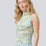 fitted top in an elastic material. NettieMD print top is sleeveless, has a high neckline, and has gatherings in the side