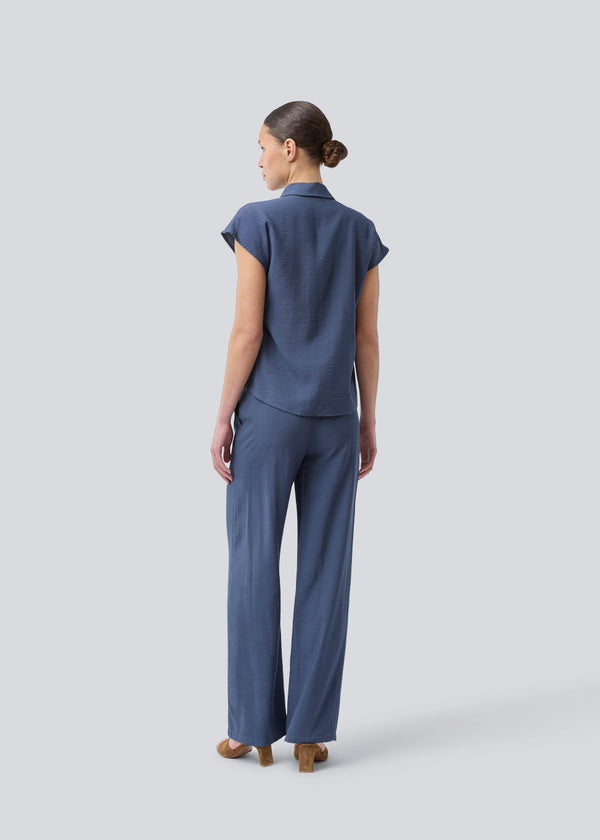 Sleeveless shirt in blue with button closure in EcoVero viscose. NickiMD SS shirt has a loose fit and gathers at the shoulder.