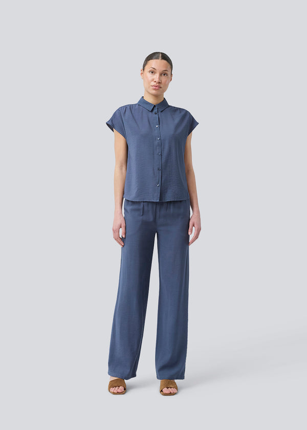 Sleeveless shirt in blue with button closure in EcoVero viscose. NickiMD SS shirt has a loose fit and gathers at the shoulder.