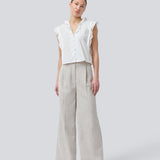 Sleeveless white top with frill details and a button closure in front. NIkkoMD top is slightly cropped and has a v-neck.