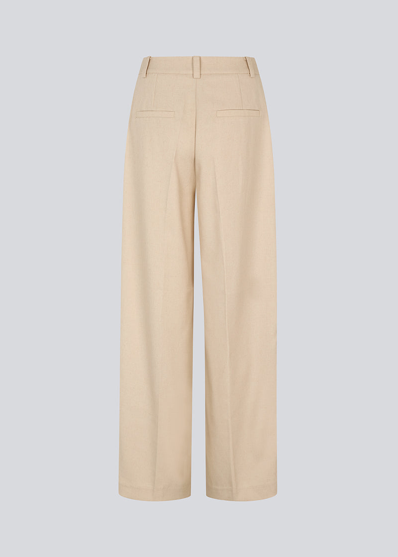 NormaMD pants in beige have a medium-high waist, zipper, side pockets, and paspoil pocket in the back.