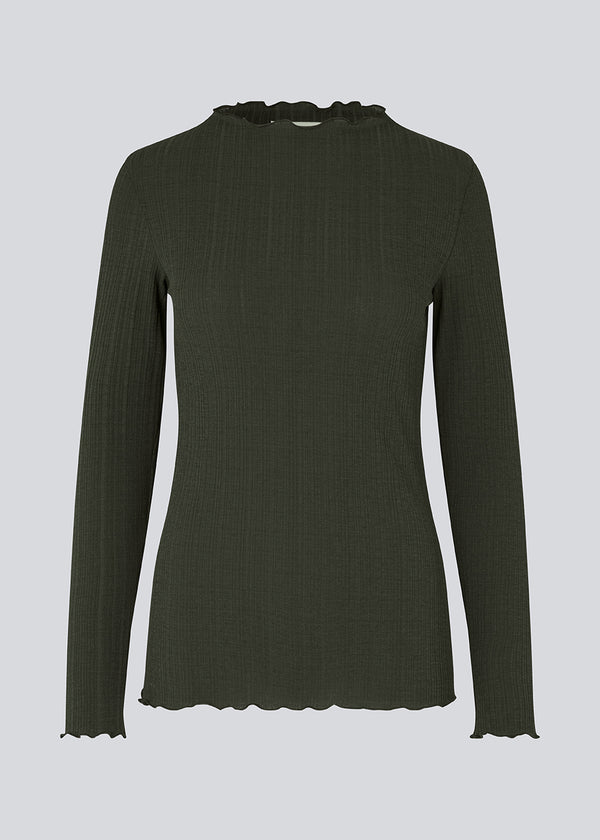 Tight-fitted, long sleeved t-shirt in dark green with ruffled trimmings on sleeves, at the neck and bottom. Oasis t-neck fits perfectly as a basic style in the wardrobe. The model is 173 cm and wears a size S/36