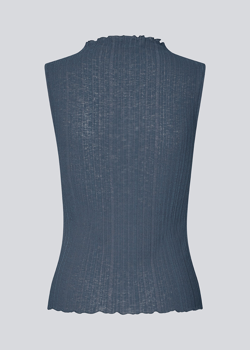 Sleeveless top in a structured material with a high neck. OasisMD top has wavy hems at neckline, arm hole and hem.