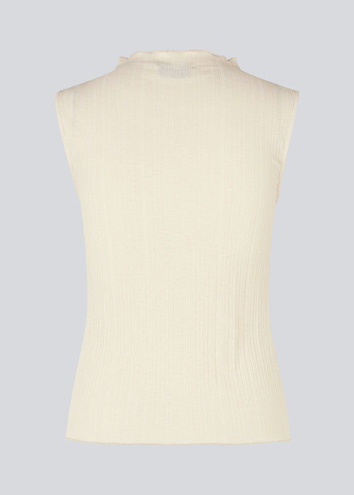 Sleeveless top in beige in a structured material with a high neck. OasisMD top has lettuce hems at neckline, arm hole and hem. The model is 175 cm and wears a size S/36. The model is 173 cm and wears a size S/36