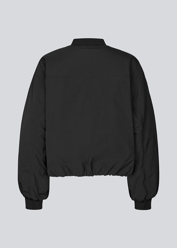 Padded black bomber jacket with gatherings at the sleeves. Obimd jacket is slightly cropped and has a zipper closure and two front pockets.&nbsp;