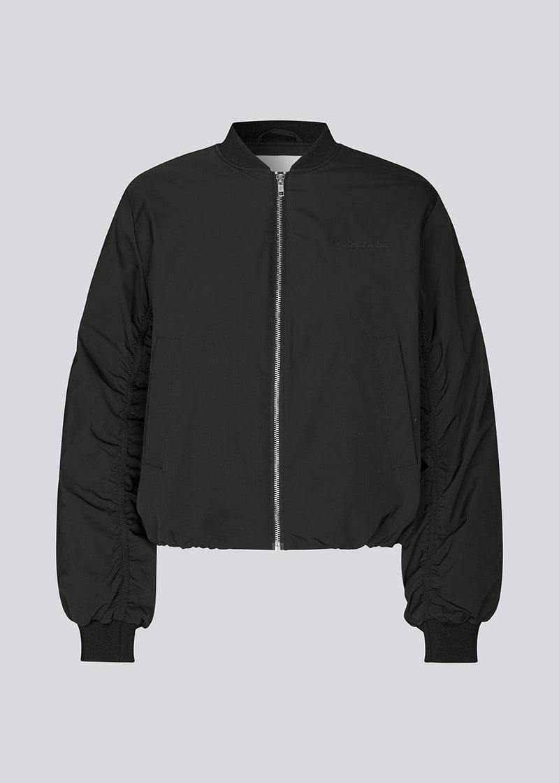 Padded black bomber jacket with gatherings at the sleeves. Obimd jacket is slightly cropped and has a zipper closure and two front pockets.&nbsp;