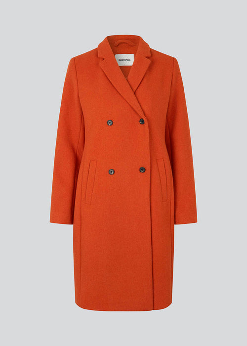 Beautiful, knee-length wool coat. Odelia coat, in the color Bright Cherry, is closed at front by 4 buttons and is fitted around the waist, which gives a feminine look. Because of the high content of wool the jacket will be perfect for fall and the mild winters.