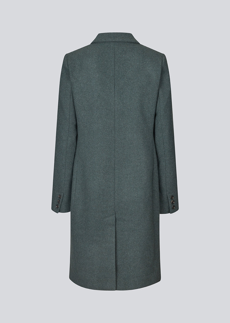 Beautiful, knee-length wool coat in dark olive green. Odelia coat is closed at front by 4 buttons and is fitted around the waist, which gives a feminine look. Because of the high content of wool the jacket will be perfect for fall and the mild winters.