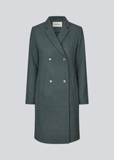 Beautiful, knee-length wool coat in dark olive green. Odelia coat is closed at front by 4 buttons and is fitted around the waist, which gives a feminine look. Because of the high content of wool the jacket will be perfect for fall and the mild winters.