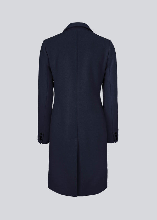 Beautiful, knee-length wool coat in navy sky. Odelia coat is closed at front by 4 buttons and is fitted around the waist, which gives a feminine look. Because of the high content of wool the jacket will be perfect for fall and the mild winters.