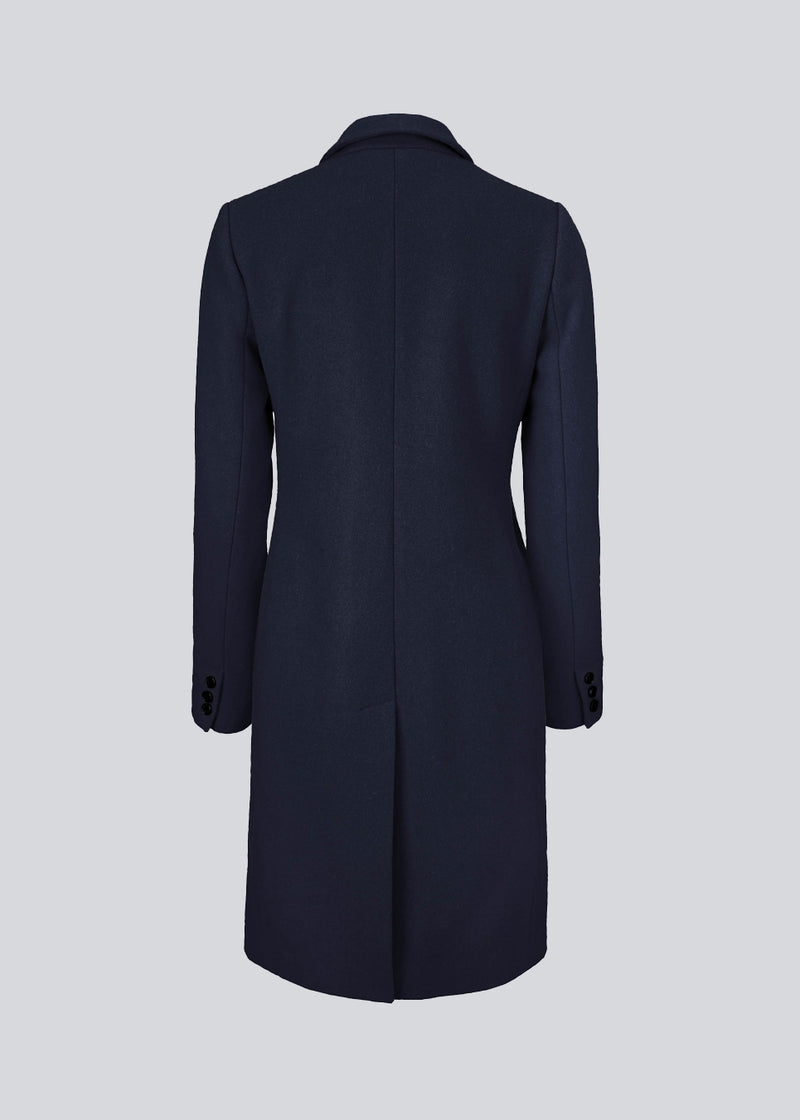 Beautiful, knee-length wool coat in navy sky. Odelia coat is closed at front by 4 buttons and is fitted around the waist, which gives a feminine look. Because of the high content of wool the jacket will be perfect for fall and the mild winters.