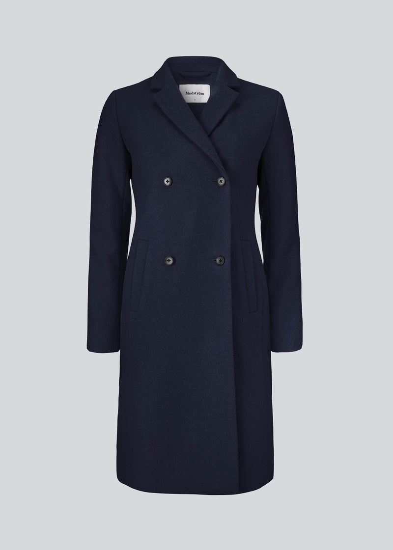 Beautiful, knee-length wool coat in navy sky. Odelia coat is closed at front by 4 buttons and is fitted around the waist, which gives a feminine look. Because of the high content of wool the jacket will be perfect for fall and the mild winters.
