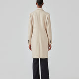 Beautiful, knee-length wool coat. Odelia coat, in season color Summer Sand, is closed at front by 4 buttons and is fitted around the waist, which gives a feminine look. Because of the high content of wool the jacket will be perfect for fall and the mild winters.