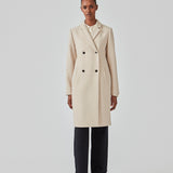Beautiful, knee-length wool coat. Odelia coat, in season color Summer Sand, is closed at front by 4 buttons and is fitted around the waist, which gives a feminine look. Because of the high content of wool the jacket will be perfect for fall and the mild winters.