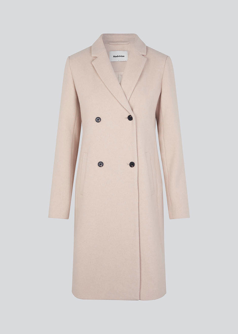 Beautiful, knee-length wool coat. Odelia coat, in season color Summer Sand, is closed at front by 4 buttons and is fitted around the waist, which gives a feminine look. Because of the high content of wool the jacket will be perfect for fall and the mild winters.