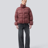 Red puffer jacket with a high neck in 100% recycled polyester. Odinmd jacket has a zipper closure and an adjustable strap at the sleeve. The model is 175 cm and wears a size s/36.