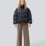Black puffer jacket with a high neck in 100% recycled polyester. Odinmd jacket has a zipper closure and an adjustable strap at the sleeve. The model is 175 cm and wears a size s/36.