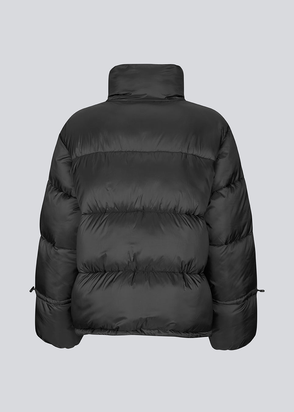 Black puffer jacket with a high neck in 100% recycled polyester. Odinmd jacket has a zipper closure and an adjustable strap at the sleeve. The model is 175 cm and wears a size s/36.