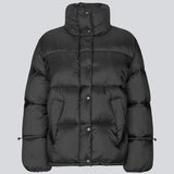 Black puffer jacket with a high neck in 100% recycled polyester. Odinmd jacket has a zipper closure and an adjustable strap at the sleeve. The model is 175 cm and wears a size s/36.