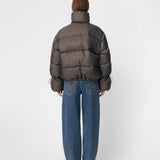 Puffer jacket with a high neck in 100% recycled polyester. Odinmd jacket has a zipper closure and an adjustable strap at the sleeve. The model is 175 cm and wears a size s/36.