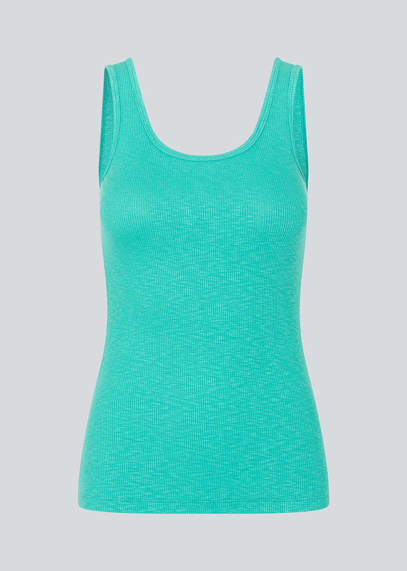 Olla top in turquoise is a simple tanktop in a soft ribmaterial. The top has a tight and figure-hugging silhouette which has a soft feel under a knitted sweater or shirt. The model is 173 cm and wears a size S/36