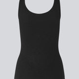Olla top is a simple black tank top in a soft rib-material. The top has a tight and figure-hugging silhouette which has a soft feel under a knitted sweater or shirt.