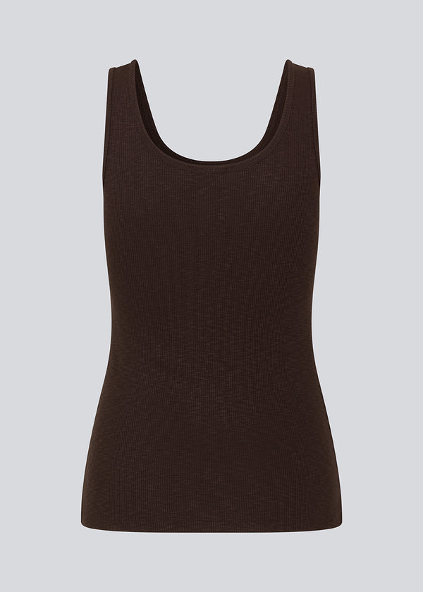 Olla top is a simple tanktop in brown in a soft ribmaterial. The top has a tight and figure-hugging silhouette which has a soft feel under a knitted sweater or shirt. The model is 173 cm and wears a size S/36