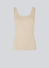 Olla top is a simple beige tank top in a soft rib-material. The top has a tight and figure-hugging silhouette which has a soft feel under a knitted sweater or shirt.