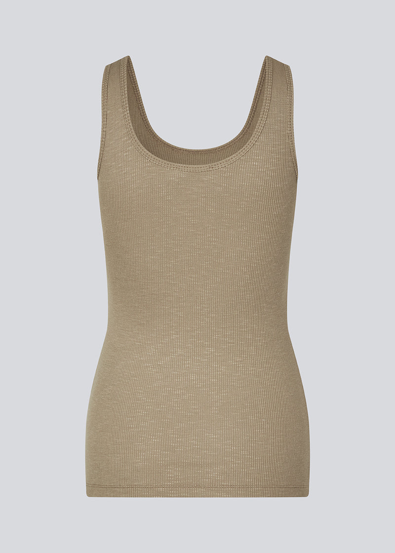 Olla top in light brown is a simple tanktop in a soft ribmaterial. The top has a tight and figure-hugging silhouette which has a soft feel under a knitted sweater or shirt.&nbsp;