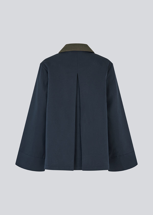 Lose jacket with corduroy collar and hidden press buttons. Orkidemd jacket has an inverted pleat on the back. The model is 175 cm and wears a size s/36.