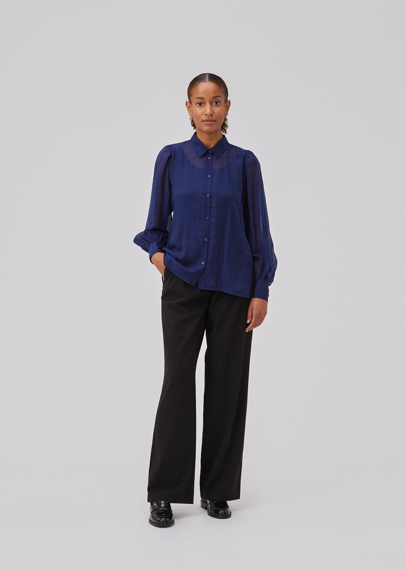 Classic shirt in blue in a light and airy material. Oskar shirt has a relaxed fit with voluminous balloon sleeves finished with a wide cuff. The shirt is a bit sheer for an ultra feminine expression.