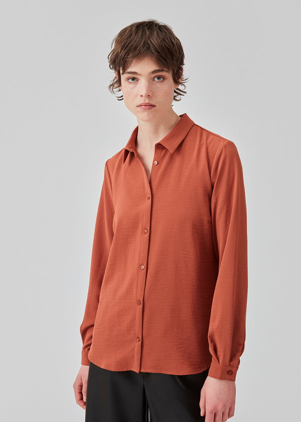 Classic shirt in the color maple in a loose and relaxed silhouette. Ossa shirt has a small collar, slim cuff and buttons in a matching colour for a sleek design. The model is 173 cm and wears a size S/36