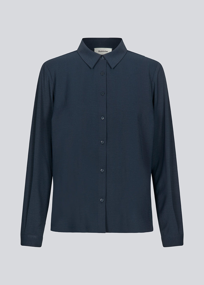 Classic navy shirt in a loose and relaxed silhouette. Ossa shirt has a small collar, slim cuff and buttons in a matching colour for a sleek design. The model is 173 cm and wears a size S/36