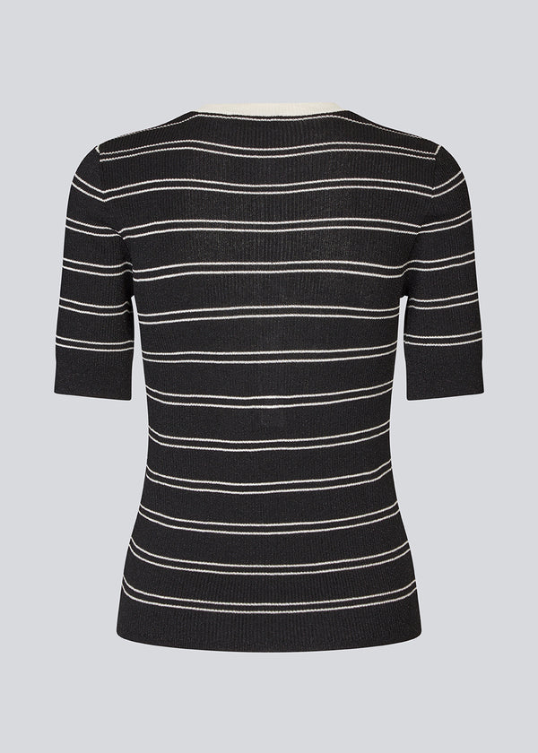 Short-sleeved polo in shimmery knit in the color Black Stripe. Pacifico SS polo has a tight fit and a placket with 5 buttons. The model is 175 cm and wears a size s/36.