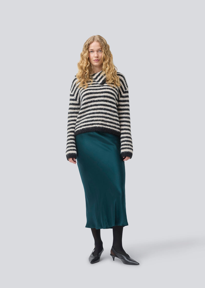 Soft knit in recycled polyester. Packermd rollneck has long sleeves and a high neckline with a side slit. The model is 175 cm and wears a size s/36.