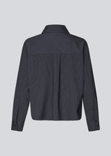Slightly cropped shirt with wide sleeves. Paitynmd shirt has a front button closure, shirt collar, and a chest pocket.